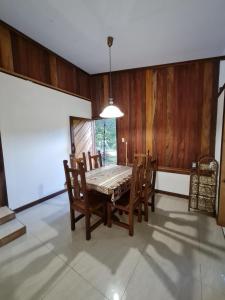 a dining room with a table and wooden walls at Casa Samia in Cahuita