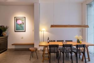 - une salle à manger avec une table et des chaises en bois dans l'établissement Purple Hue - Charming Riverside, à Hue