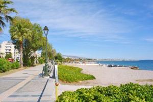 a street light next to a beach with palm trees at Luxury at its best beach condo in Palaio Faliro in Athens