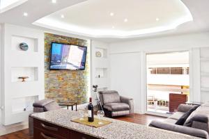 a living room with a tv on a wall at Luxury at its best beach condo in Palaio Faliro in Athens