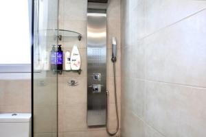 a shower with a glass door in a bathroom at Luxury at its best beach condo in Palaio Faliro in Athens