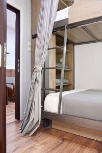 a bedroom with a bunk bed and a wooden floor at Luxury at its best beach condo in Palaio Faliro in Athens
