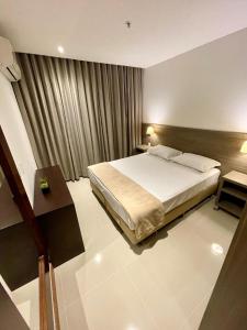 a hotel room with a bed and a desk and a bed sidx sidx sidx at Apto tipo Flat Midas Riocentro - Barra da Tijuca- Barra olímpica in Rio de Janeiro