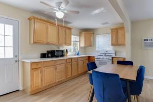 3 bedroom Mid-Wilshire Charmer near Downtown في لوس أنجلوس: مطبخ مع دواليب خشبية وطاولة مع كراسي زرقاء