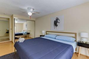 um quarto com uma cama azul e uma ventoinha de tecto em 3 bedroom Mid-Wilshire Charmer near Downtown em Los Angeles