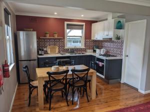 a kitchen with a table and chairs and a refrigerator at Kenna Cottage in Orange