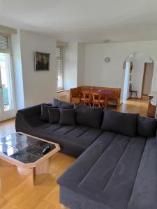 een woonkamer met een zwarte bank en een tafel bij SAVOY 26 in Interlaken