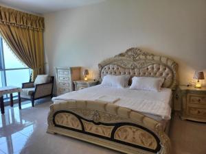 a bedroom with a large bed with a large headboard at Beachfront Holiday Homes in Ajman 