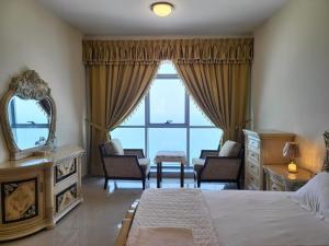 a bedroom with a bed and a large window at Beachfront Holiday Homes in Ajman 