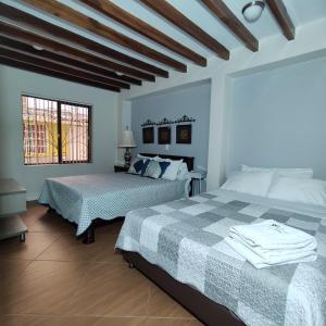 1 dormitorio con 2 camas y ventana en Los Andes Hostal, en Filandia