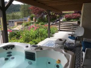 d'une baignoire installée sur une terrasse avec un jardin. dans l'établissement Lakeview Gardens B&B, à Peachland