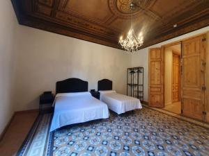 a bedroom with two beds and a chandelier at Hostal Lausanne in Barcelona +8 photos