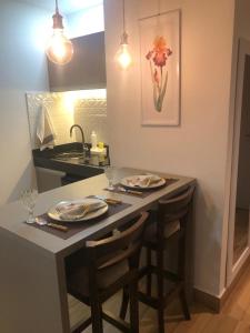 kuchnia ze stołem, krzesłami i zlewem w obiekcie Flat no Transamerica Hotel w mieście Campos dos Goytacazes