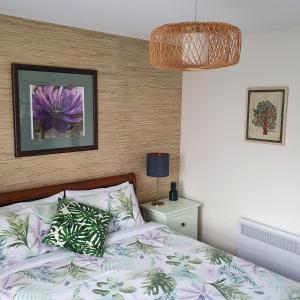 Un dormitorio con una cama con una flor morada. en Maggie's Place in Cowes, en Cowes