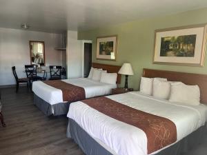 a hotel room with two beds and a table at Adobe Inn Durango in Durango