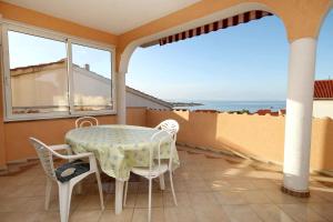 einen Tisch und Stühle auf einem Balkon mit Meerblick in der Unterkunft Apartments and rooms with a swimming pool Novalja, Pag - 9334 in Novalja