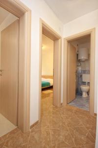 a hallway with a bathroom with a toilet and a bedroom at Apartments by the sea Vlasici, Pag - 9324 in Vlašići