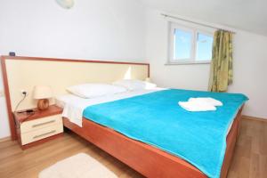 ein Schlafzimmer mit einem großen Bett mit einer blauen Decke in der Unterkunft Apartments by the sea Vlasici, Pag - 9324 in Vlašići