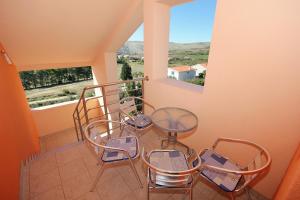 a balcony with chairs and a table and a window at Apartments by the sea Vlasici, Pag - 9324 in Vlašići