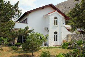 a white house with a mountain in the background at Apartments with a parking space Bosana, Pag - 9374 in Pag