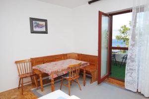 a dining room with a table and chairs and a window at Apartments with a parking space Bosana, Pag - 9374 in Pag