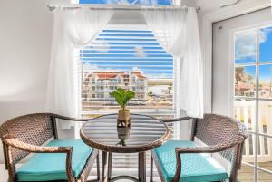 Una mesa y sillas en un balcón con ventana. en Oceanside Retreat, en Corpus Christi