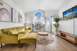 a living room with a yellow couch and a table at Oceanside Retreat in Corpus Christi