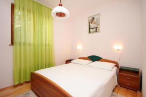 sypialnia z łóżkiem z zieloną zasłoną w obiekcie Apartments by the sea Karbuni, Korcula - 9308 w mieście Prižba