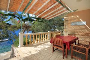 um pátio com uma mesa e cadeiras numa varanda em Apartments by the sea Karbuni, Korcula - 9308 em Prizba