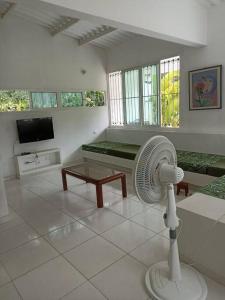 una sala de estar blanca con ventilador en una habitación en VILLETA, CASA CAMPESTRE CERCA DE PAYANDE, en Villeta