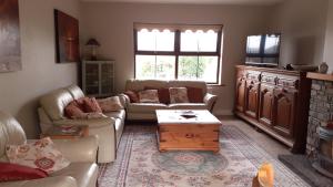 a living room with a couch and a coffee table at Cuckoo Tree House Glengarriff Beara Peninsula in Glengarriff
