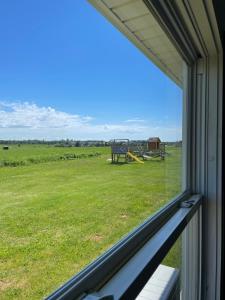 een raam met uitzicht op een veld vanuit een huis bij PEI Cottage Rental in Borden-Carleton