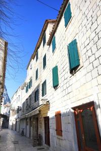 a building with green shuttered windows on a street at Apartments with WiFi Omis - 9460 in Omiš