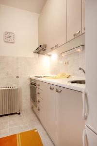 a kitchen with white cabinets and a sink at Apartments with WiFi Omis - 9460 in Omiš