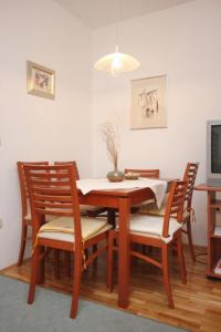 a dining room table with four chairs and a television at Apartments with WiFi Omis - 9460 in Omiš