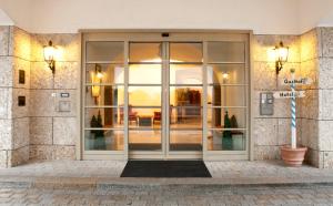 una entrada a un edificio con puertas de cristal en Hotel zur Post, en Aschheim