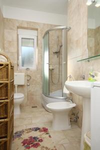 a bathroom with a shower and a toilet and a sink at Apartments by the sea Slatine, Ciovo - 9454 in Slatine