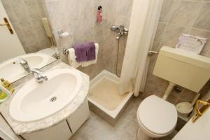 een badkamer met een wastafel, een toilet en een douche bij Apartments by the sea Slatine, Ciovo - 9454 in Slatine