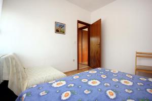 a bedroom with a bed with a blue comforter at Apartment Bilo 9467d in Zaboric
