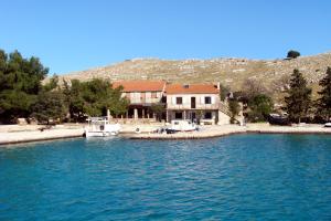 a house on the shore of a body of water at Secluded fisherman's cottage Cove Vela Proversa, Kornati - 9471 in Vala