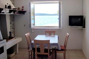 a kitchen with a table and chairs and a window at Secluded fisherman's cottage Cove Vela Proversa, Kornati - 9471 in Vala