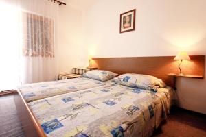 a hotel room with two beds and a window at Apartments by the sea Sevid, Trogir - 9468 in Sevid