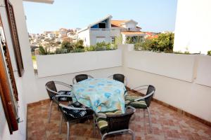 a table and chairs on a balcony with a view at Apartments by the sea Sevid, Trogir - 9468 in Sevid