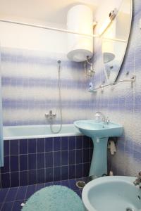a blue tiled bathroom with a sink and a mirror at Apartments by the sea Racisce, Korcula - 9337 in Račišće +11 photos