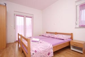 sypialnia z łóżkiem i stołem oraz 2 oknami w obiekcie Apartments with a parking space Poljica, Trogir - 10010 w Marinie