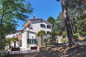 uma vista exterior de uma casa com árvores em Apartments with a parking space Rabac, Labin - 9652 em Rabac