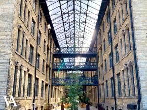 a large building with a tree in the middle of it at Velvet Apartments - Conditioning House in Bradford