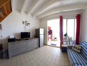 uma sala de estar com um sofá e um frigorífico em Studio T1 bis La Belle Vue, vue mer, wifi, plage à 50m em Le Moule