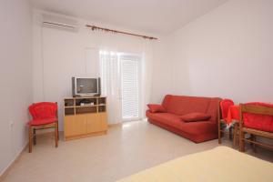 a living room with a red couch and a tv at Studio Zubovici 9365a in Zubovići