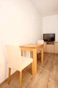 uma mesa e cadeira num quarto com televisão em Apartment Duce 9437g em Dugi Rat